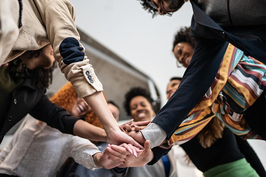 looking up under a group of business people putting their hands together