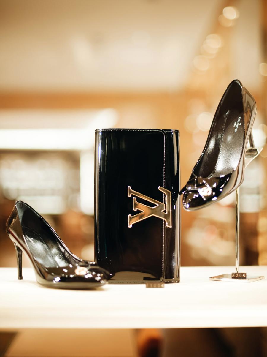 stock image of a sales display of a Louis Vuitton handbag in the center and Louis Vuitton shoes on either side
